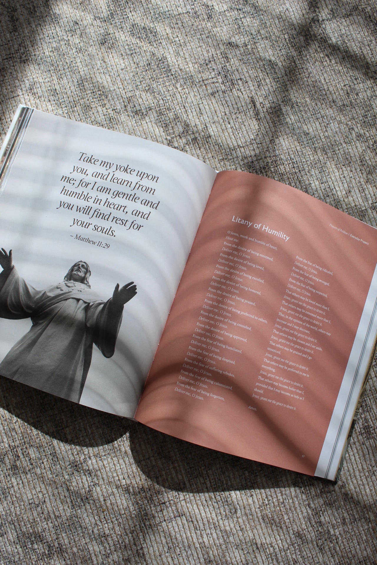 open Catholic prayer book with traditional prayers and reflections from scripture catechism and saints